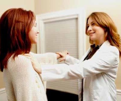 Photo of a female practitioner using muscle testing to assess a client's energetic status