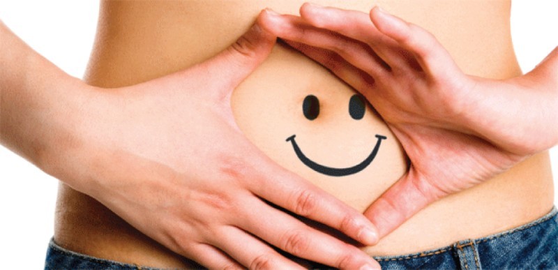 Photo showing a smiley drawn on a woman's belly to represent good digestion
