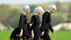 Photo of three Amish girls walking across a field